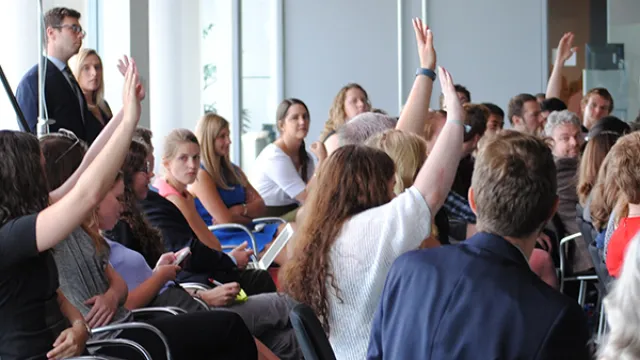 Students in a classroom raising their hands