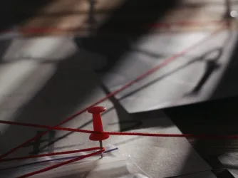 Close up of investigation board with map pinned evidences and red thread connecting clues