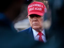 Donald Trump speaks to reporters wearing red MAGA hat