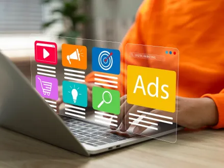 Person at a computer with a digital display showing advertisements