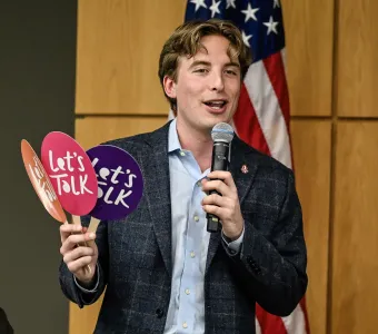 FIRE staffer Will Harris holding up "Let's Talk" fans at an event in Utah