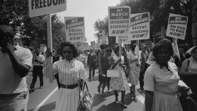 Photo of African American women at the March on Washington on 28 August 1963 carrying signs for equal rights, integrated schools, decent housing, and an end to bias.