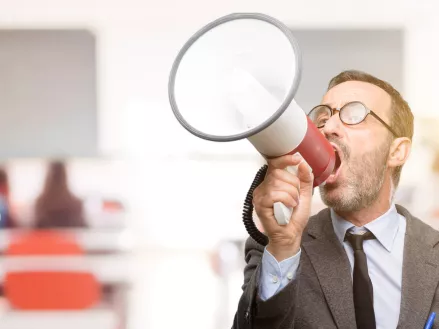 Teacher shouting holding a megaphone in a classroom