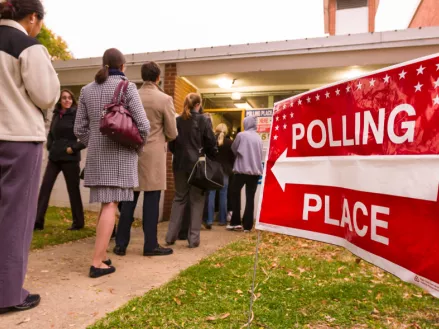 Voting polling place sign and people lined up on presidential election day 