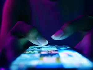 woman's fingers navigatings social media in the dark